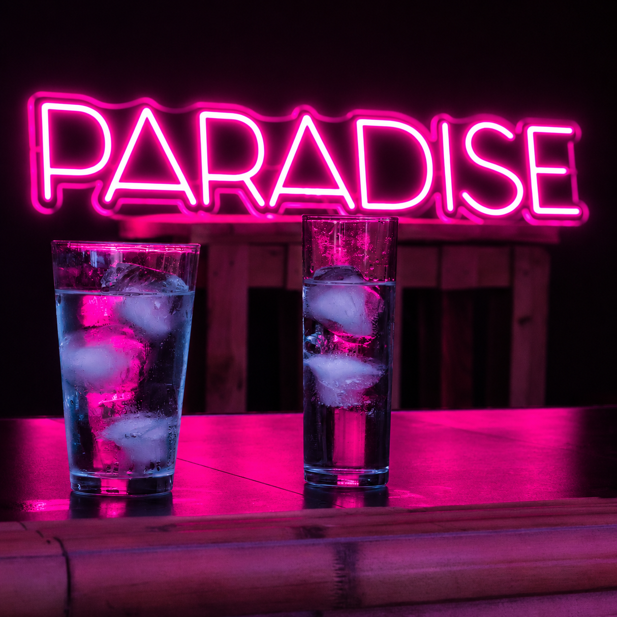 Cartel PARADISE — neón rosa en barra
